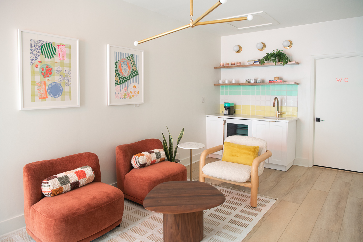 small seating area with orange chairs and kitchenette