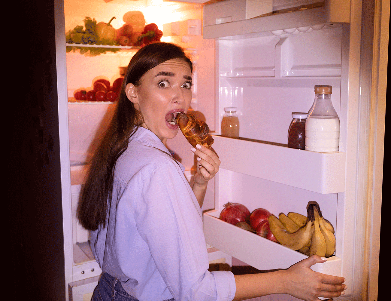 Woman sneakily eating croissant.